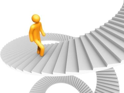 Bold yellow figure climbing circular staircase representing growth and progress in professional development.